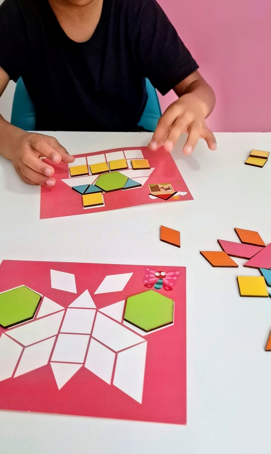 Atividade de tangram com peças geométricas coloridas sobre a mesa da clínica