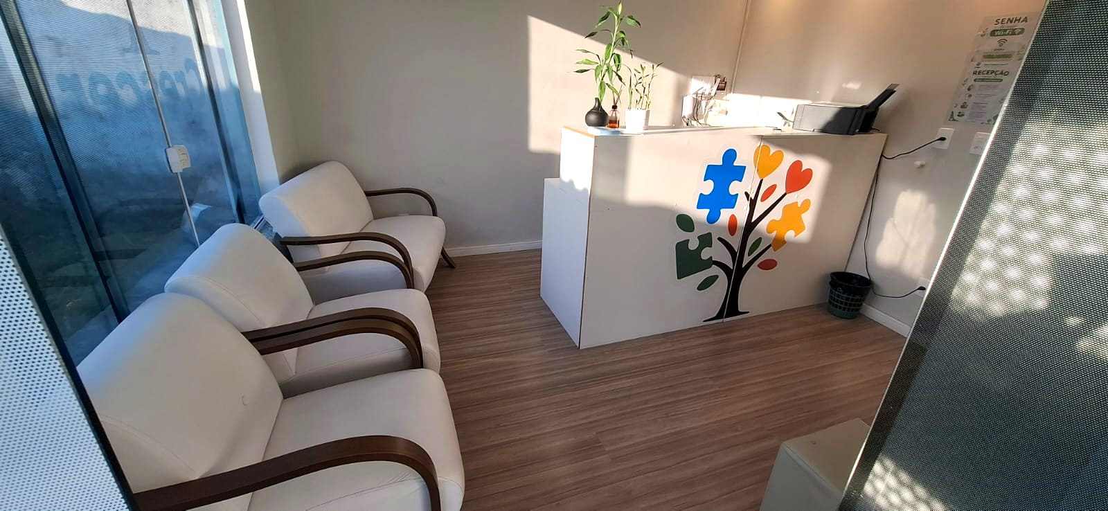 Recepção da clínica com poltronas e a árvore da marca