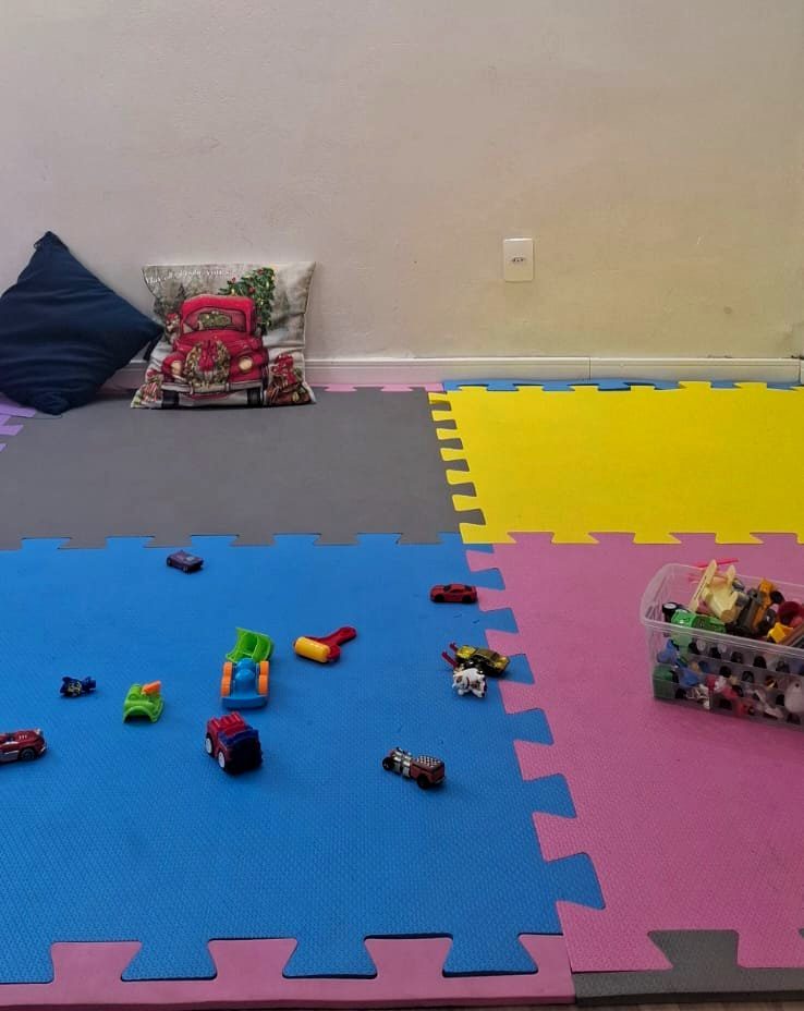 Sala lúdica com tatame colorido e brinquedos