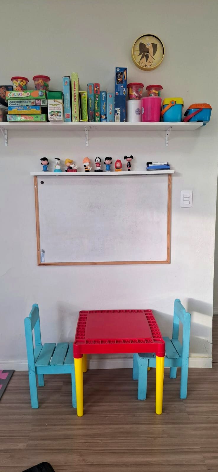 Sala de atendimento individual com mesa infantil, quadro branco e jogos pedagógicos
